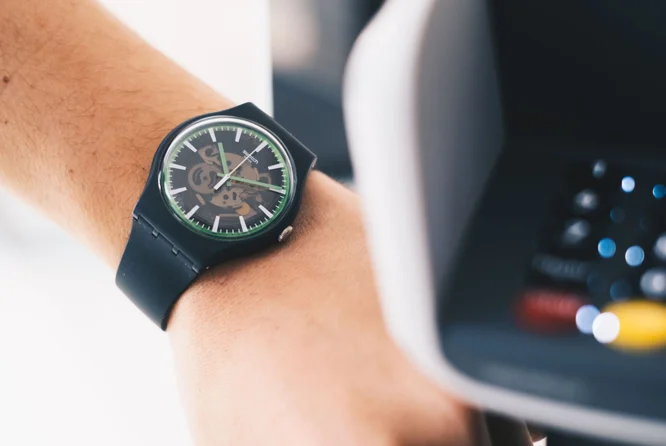 Mann bezahlt kontaktlos mit Swatch Pay