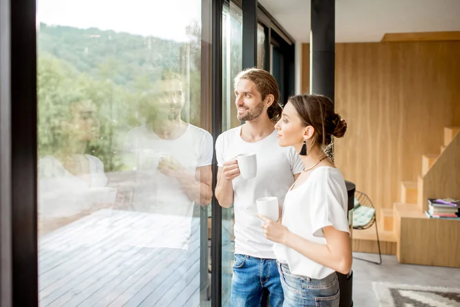 Paar genießt Kaffee am großen Fenster