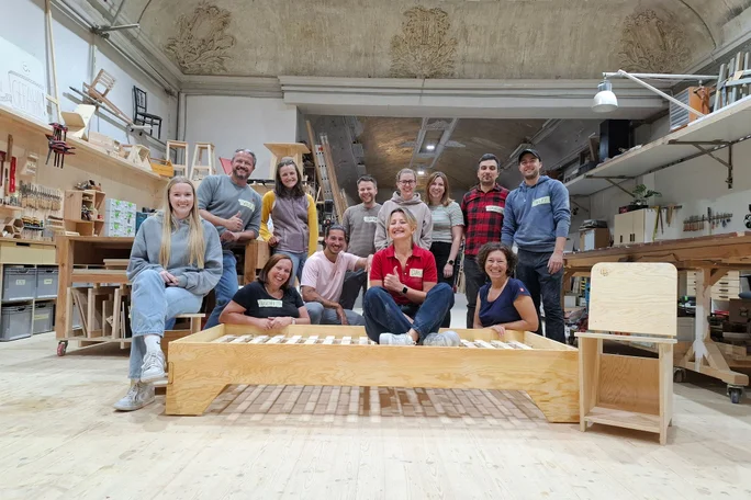 Corporate Volunteering: Kolleg:innen mit selbstgebautem Bett und Nachttisch