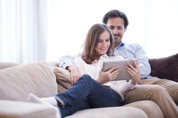 Paar entspannt sich mit Tablet auf dem Sofa