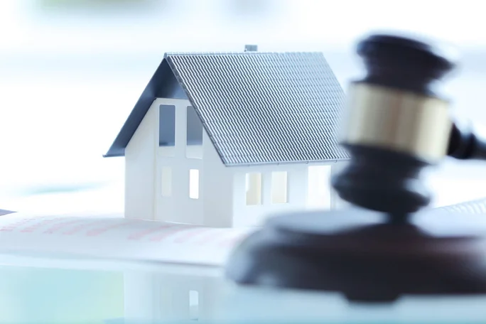 Miniaturhaus mit Hammer auf Tisch