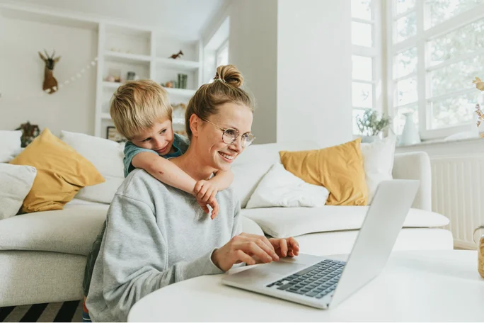Frau und Kind im Wohnzimmer am Laptop