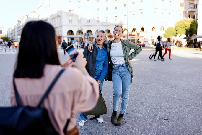 A mature woman taking a picture of her smiling friends