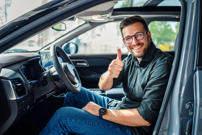Ein junger Mann in einem Auto lächelt
