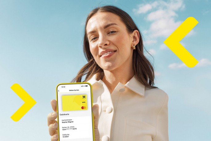 Frau hält Smartphone mit Debitkarte in die Kamera